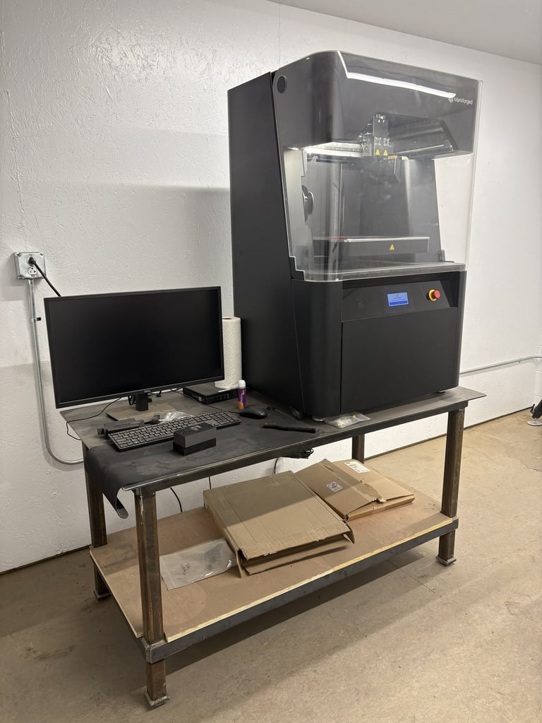 3D printer with control monitor on industrial workbench in laboratory setting