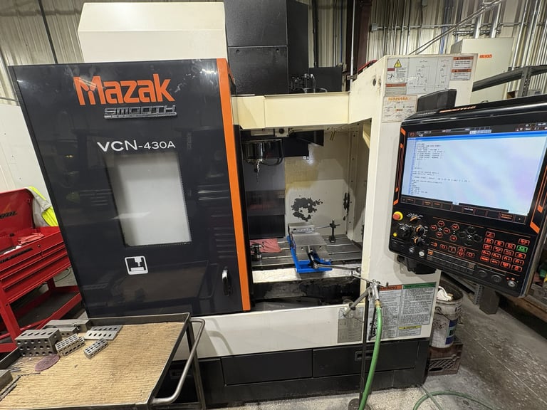 Mazak VCN-430A CNC vertical machining center in an industrial workshop with control panel and monitor