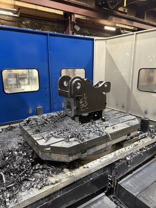 Vintage film camera displayed on a concrete platform inside an industrial gallery space with blue and white metal walls