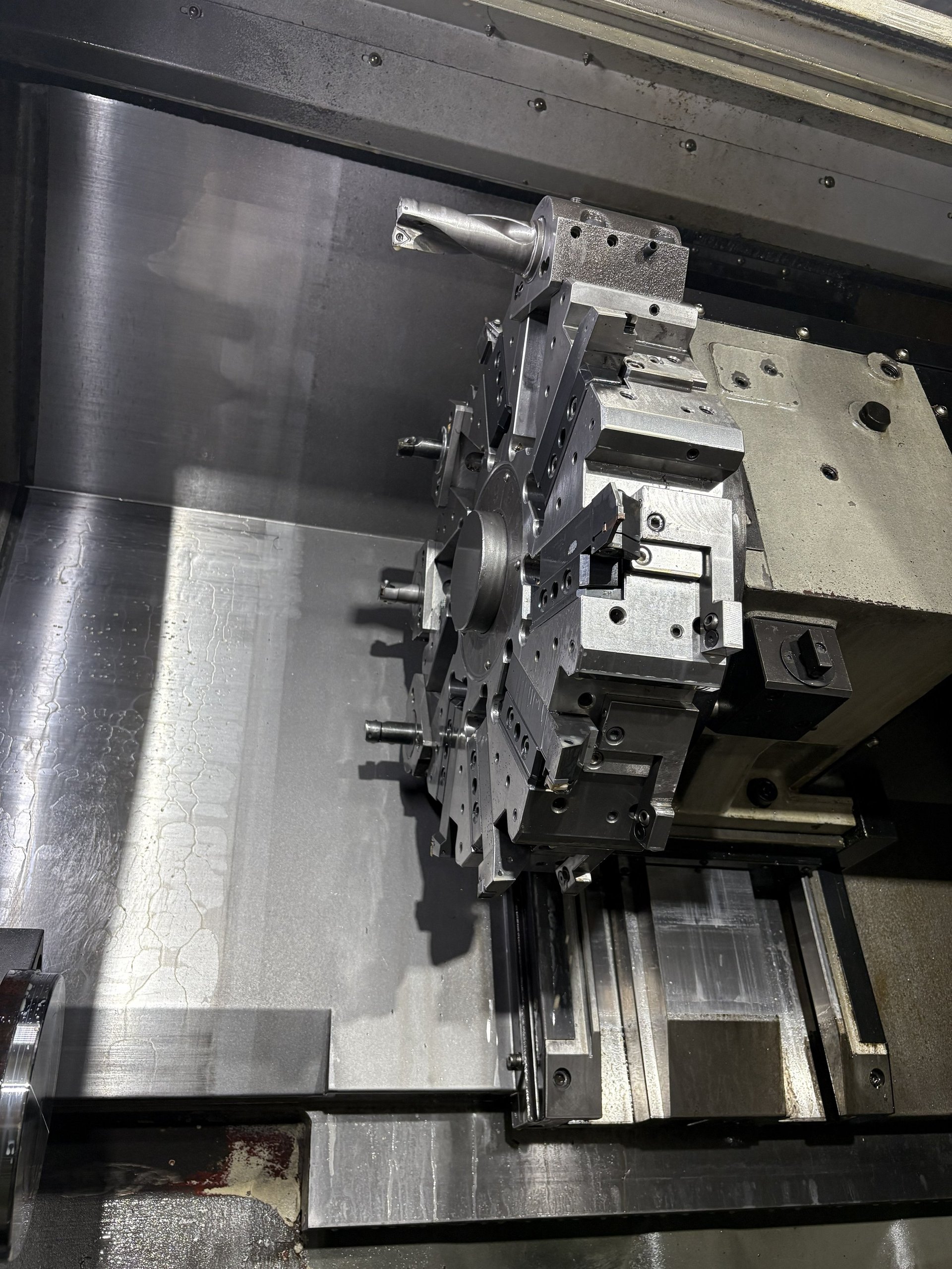 Industrial CNC lathe chuck and spindle assembly with metal workholding apparatus mounted on machine bed
